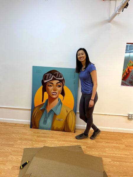 Curator Kelly Lan with portrait of Hazel Lee, early Chinese American female fighter pilot