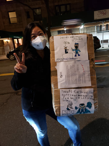 Woman wearing mask and holding large box