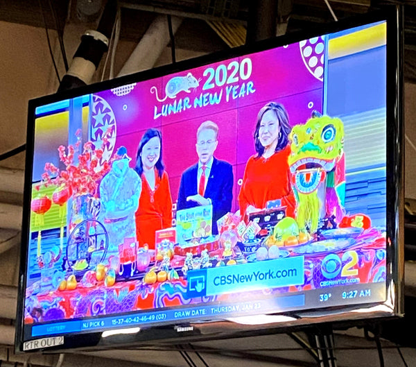 TV screen with Joanne Kwong, John Elliott, and Cindy Hsu live on CBS