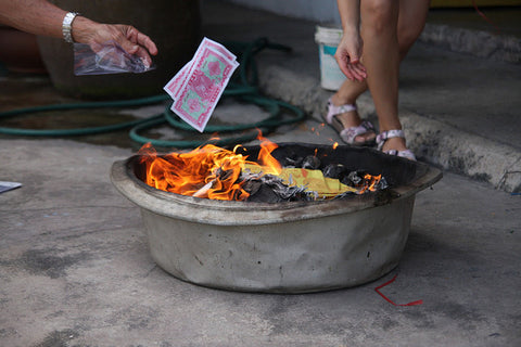 Pot with burning ghost money for an offering