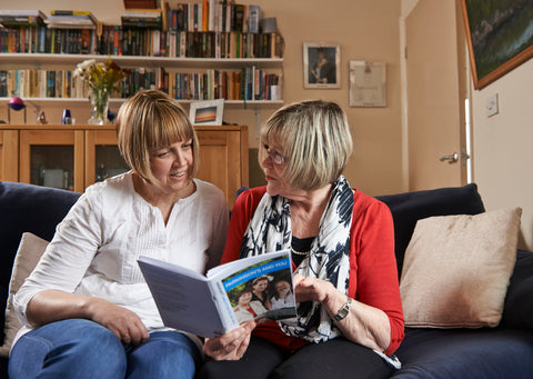 Two people looking through a Parkinson's UK information pack.