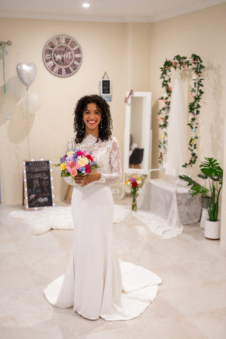 Maeva wearing a long sleeves lace wedding dress with soft crepe skirt and buttons