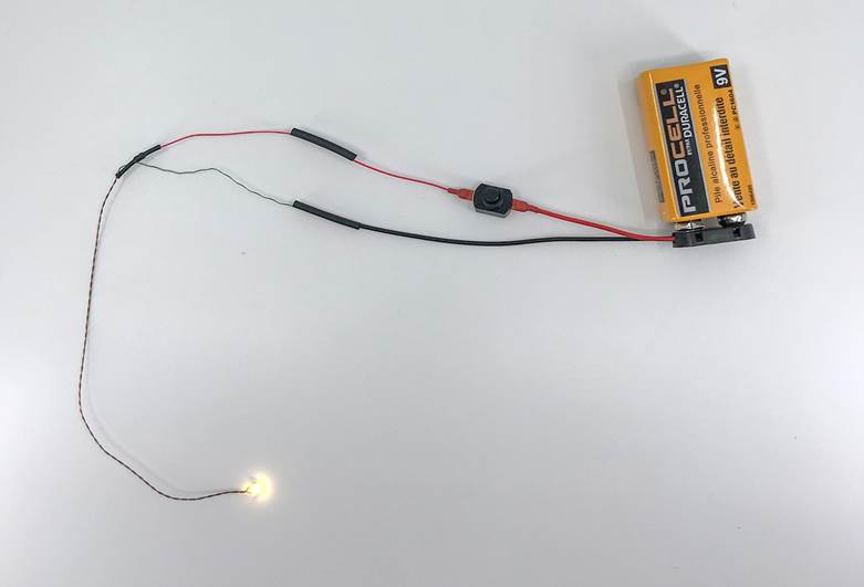 Warm white Evan Designs Chip LED connected to a 9 volt battery-Figure A