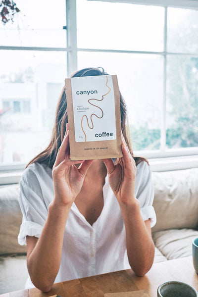 Owner Ally Walsh holding a bag of Canyon Coffee | Women of coffee