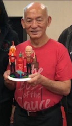 David Tran with his custom bobblehead (including a giant bottle of his Sriracha sauce) from Bobble For A Cause!