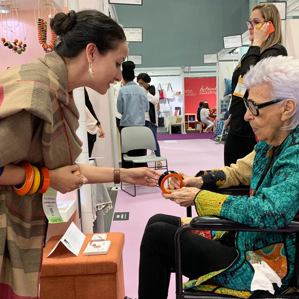 Iris Apfel at Lai booth at NY NOW 2019, with designer Puja Bhargava Kamath. Seen here wearing our Channapatna handcrafted lacquered wooden warrior dramatic bangle