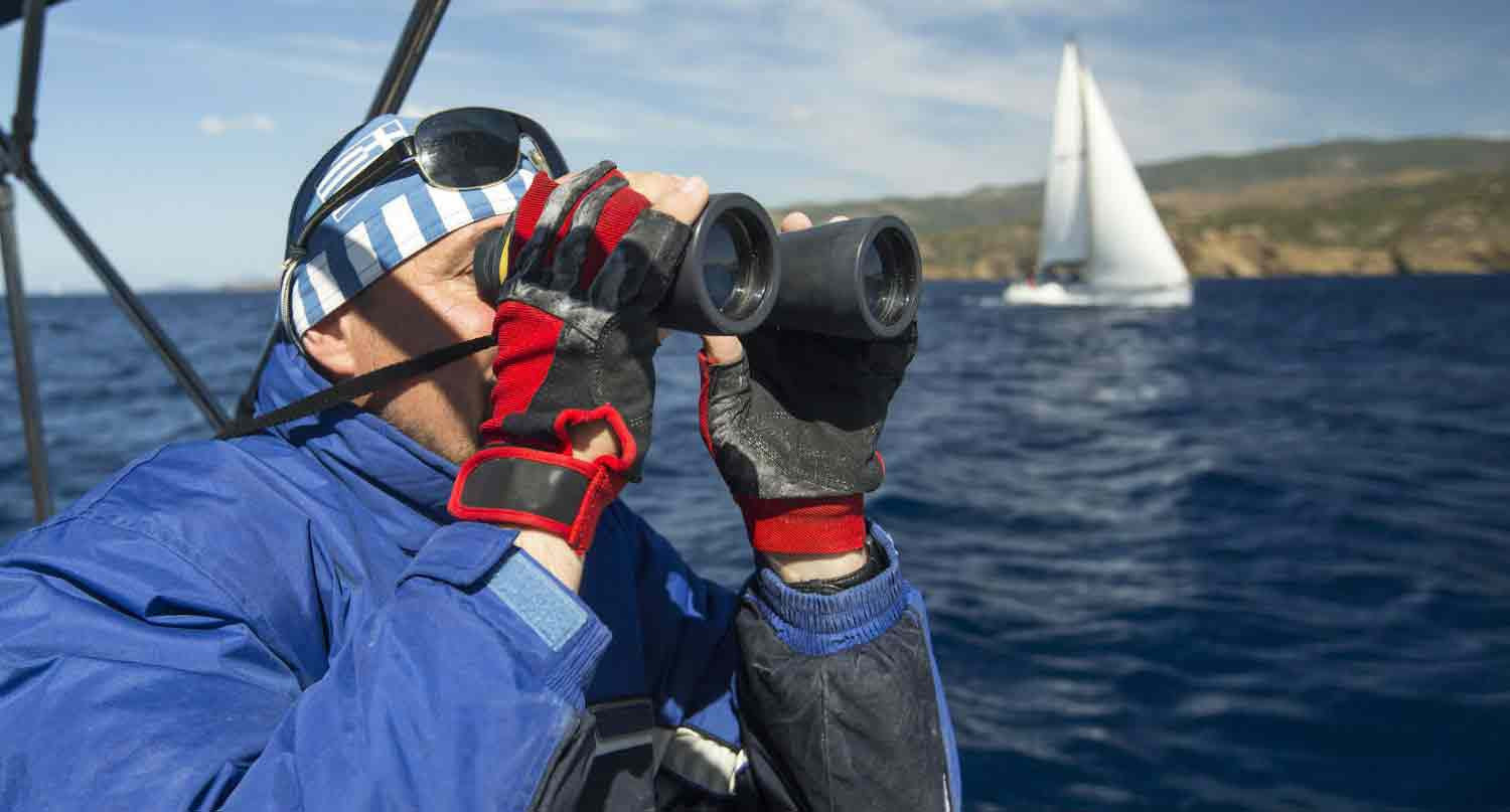 Man using binoculars on a boat