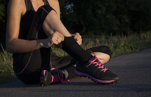 female runner pulling up socks