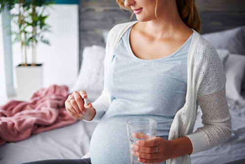 pregnant woman taking prenatal supplement