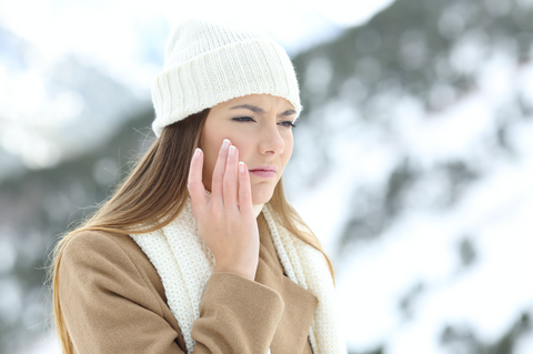 Woman touching face in winter weather
