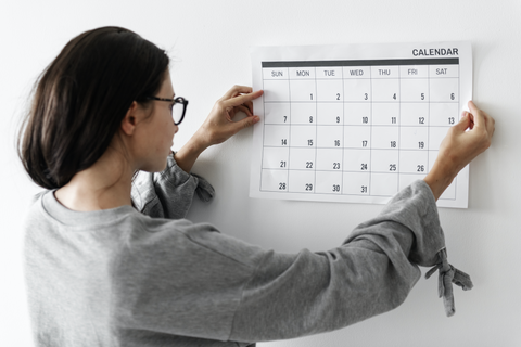 Woman Using a Wall Calendar to Plan her Bridal Beauty