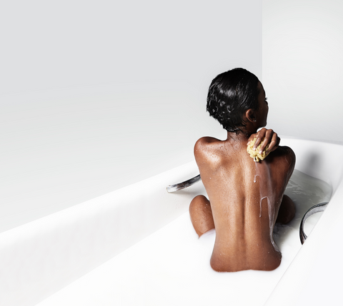 Woman bathing in milk and oatmeal to treat sunburn | ALASTIN Skincare