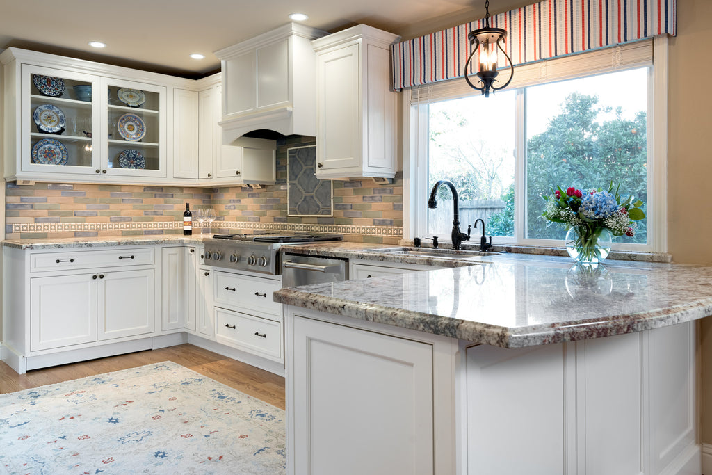 Concord California Kitchen Remodel by Interior Designer Jackie Lopey with Crystal Cabinet Works white painted inset cabinets, ogee ceramic tile inset over range top, wood floors, handmade ceramic tile backsplash, Cambria quartz countertops and Legrand Adorne undercabinet lighting system 