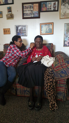 My cousin puts custom earrings on our grandmother.