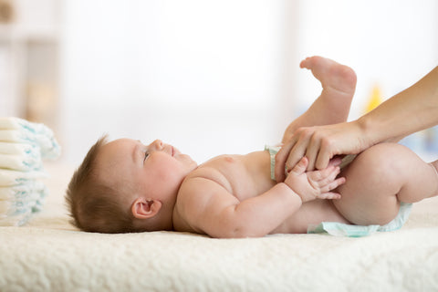 parent changing diaper has part of baby bedtime routine