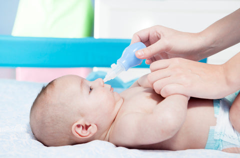 parent easing baby stuffy nose with bulb syringe