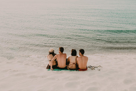 group of friends sitting at the beach