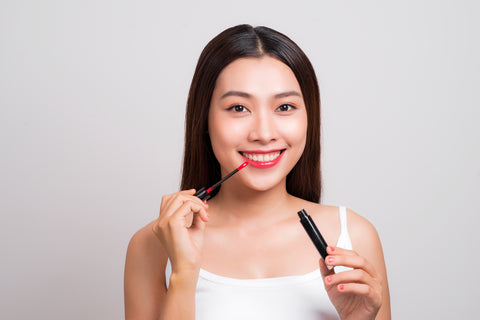 woman applying lip gloss to chapped lips