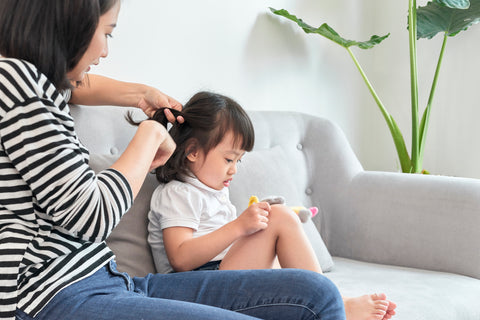 mom braiding daughters hair