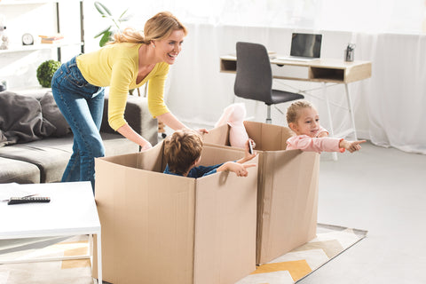 family playing with boxes making recycling for kids fun