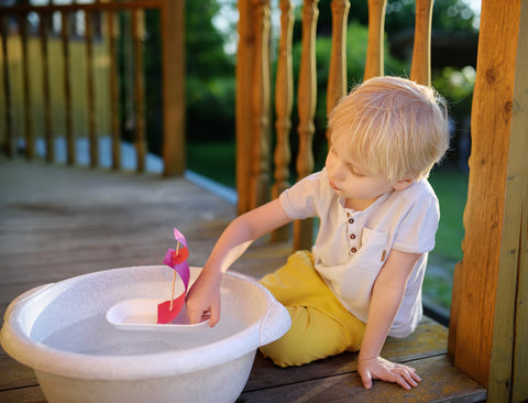 kid playing with water outside