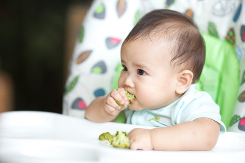 little guy eating broccoli