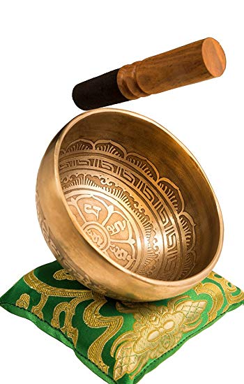 gold singing bowl with design and inscription inside green pillow underneath and mallet above 