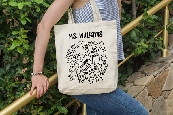 Canvas tote with the School Doodle Cloud svg cut file in black and added teacher's name
