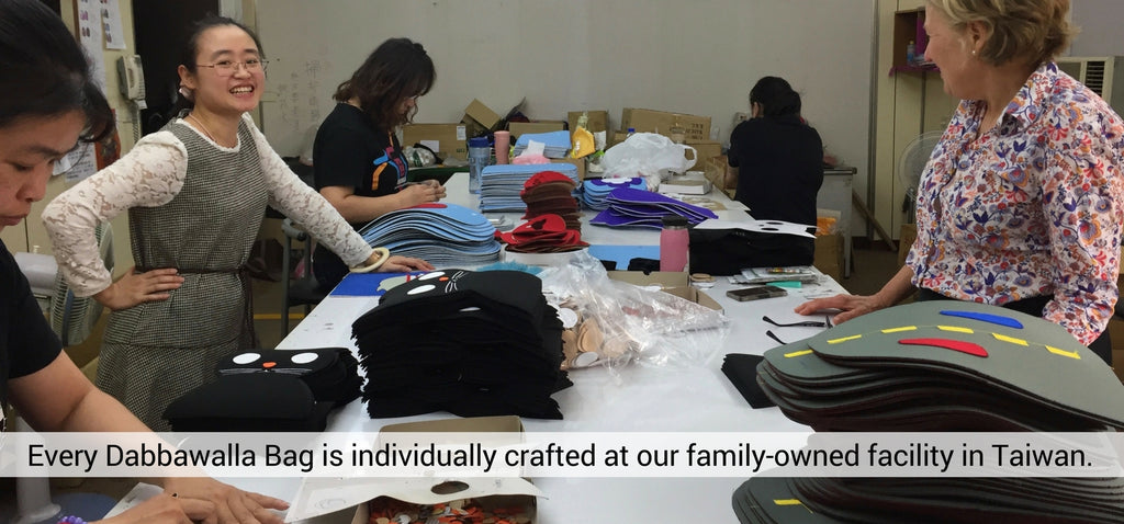 A group of women working on a table. Every dabbawalla bag is individually crafted at our family-owned facility in Taiwan.