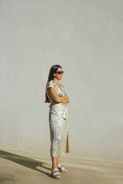 Image of Laura Egea, a Barcelona-based photographer and art director posing in a silver ensemble. 