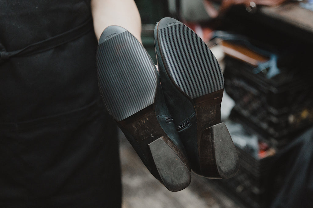  Byron Valarezo holding a pair of Coclico boots showing off the repaired sole. 