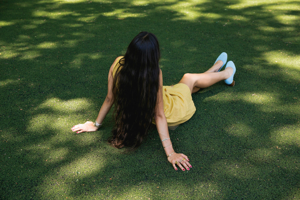Back view of Bianca Valle lounging on the grass. 