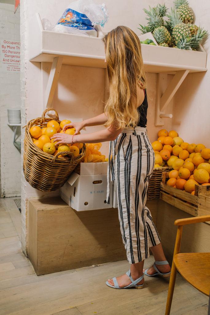 Adriana Urbina, Executive Chef at De Maria picking oranges from a basket. 