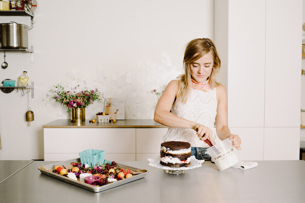 Emily Aumiller, a Brooklyn-based pastry chef in the kitchen working on a cake. 