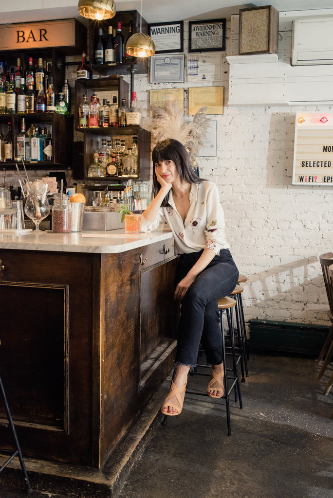 Giorgia Zedda seated at the bar at Epistrophy in her Coclico Treacle Heel in Mango leather.