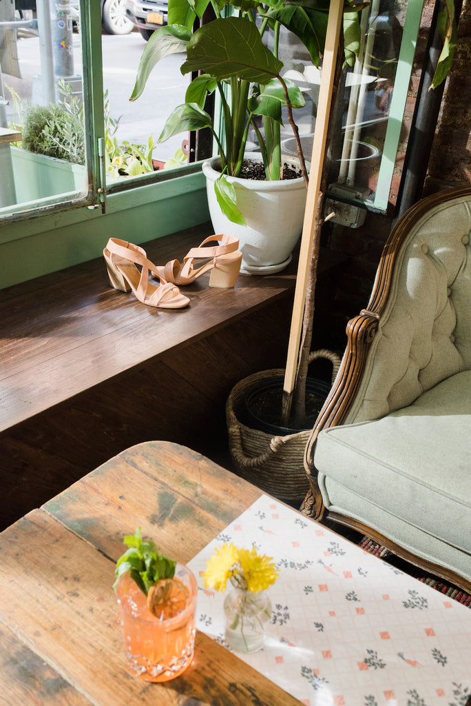 Interior of Epistrophy with Sunset in Nolita cocktail on wooden table. 