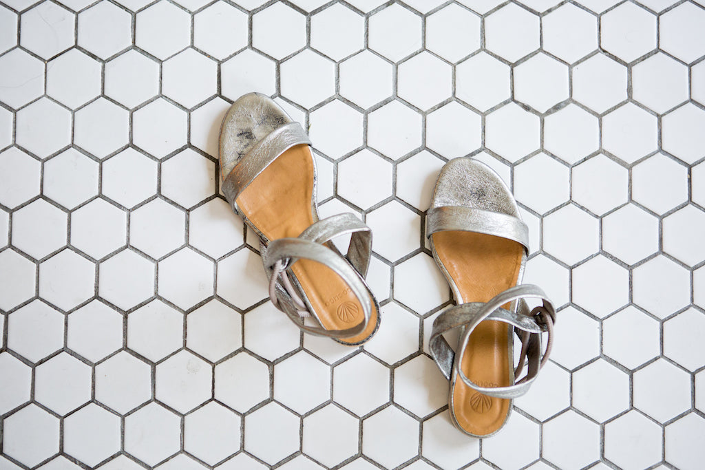 Top view of the Float Sandal in Nickel Metallic leather on beehive tile flooring. 