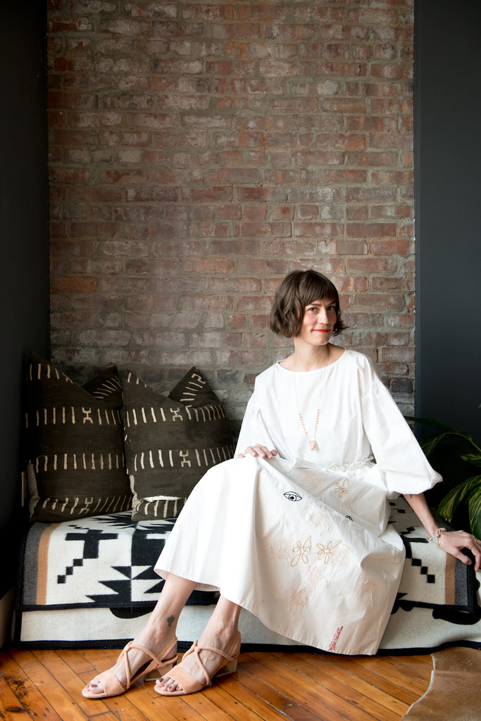 Sunlit image of Gretchen Jones smiling and lounging on the couch.