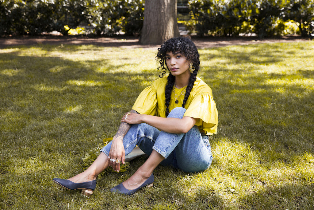 Chef, beauty, and soundness advocate, Sophia Roe seated on the grass sporting the Epic Heel. 