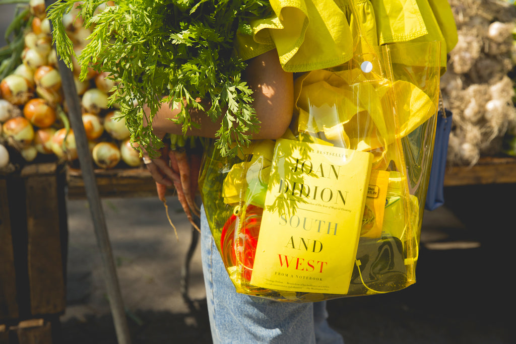 Sophia Roe carrying a transparent yellow bag and vegetables.