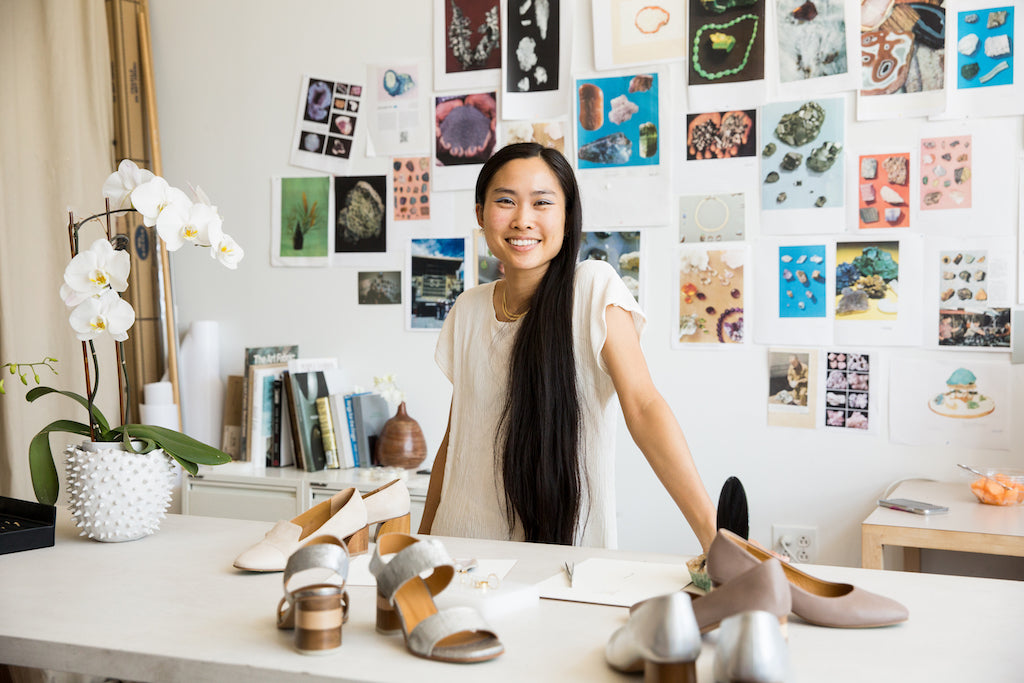 Image of Wing Yau, designer at WWAKE at the Greenpoint headquarters with several Coclico styles scattered on the table.  