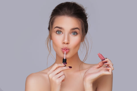 girl applying natural lip gloss for raw beauty minerals