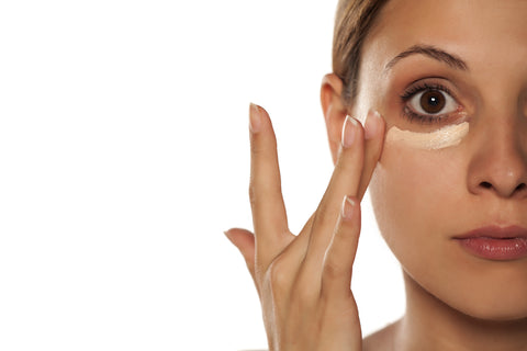 woman applying natural makeup concealer under eyes raw beauty minerals