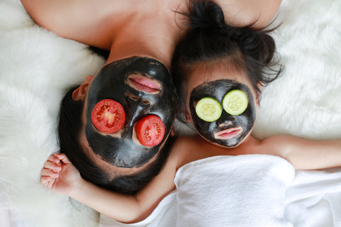mother and young daughter enjoying a charcoal mask together
