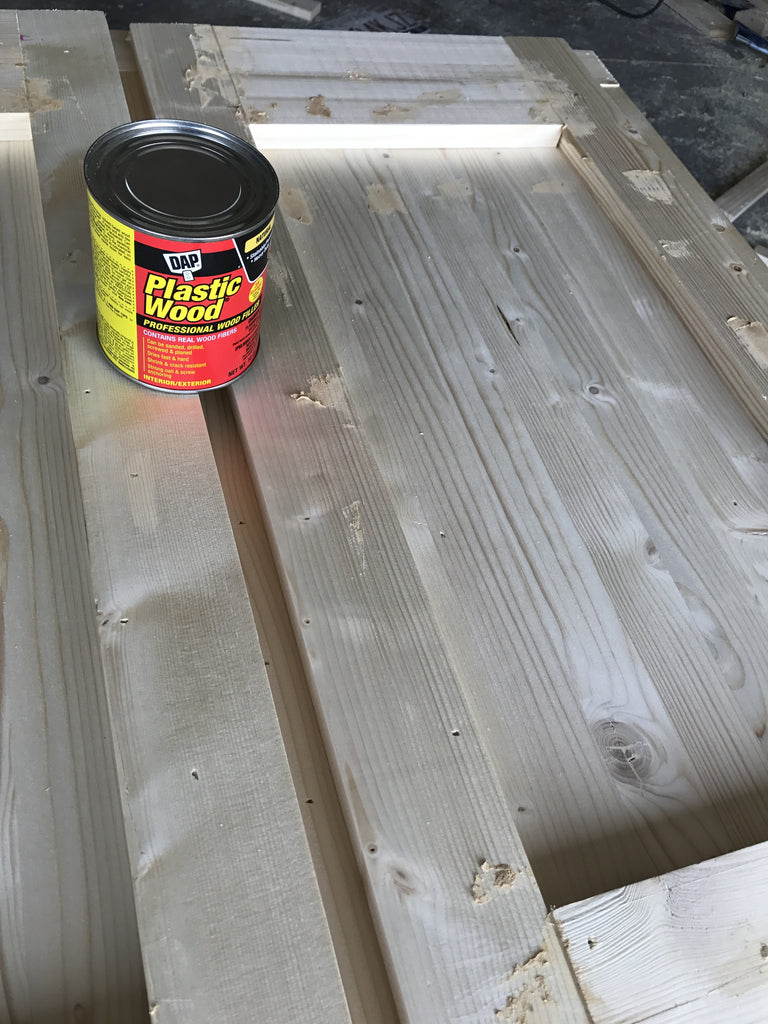 DAP Wood Filler being used on a cabinet for filling nail holes