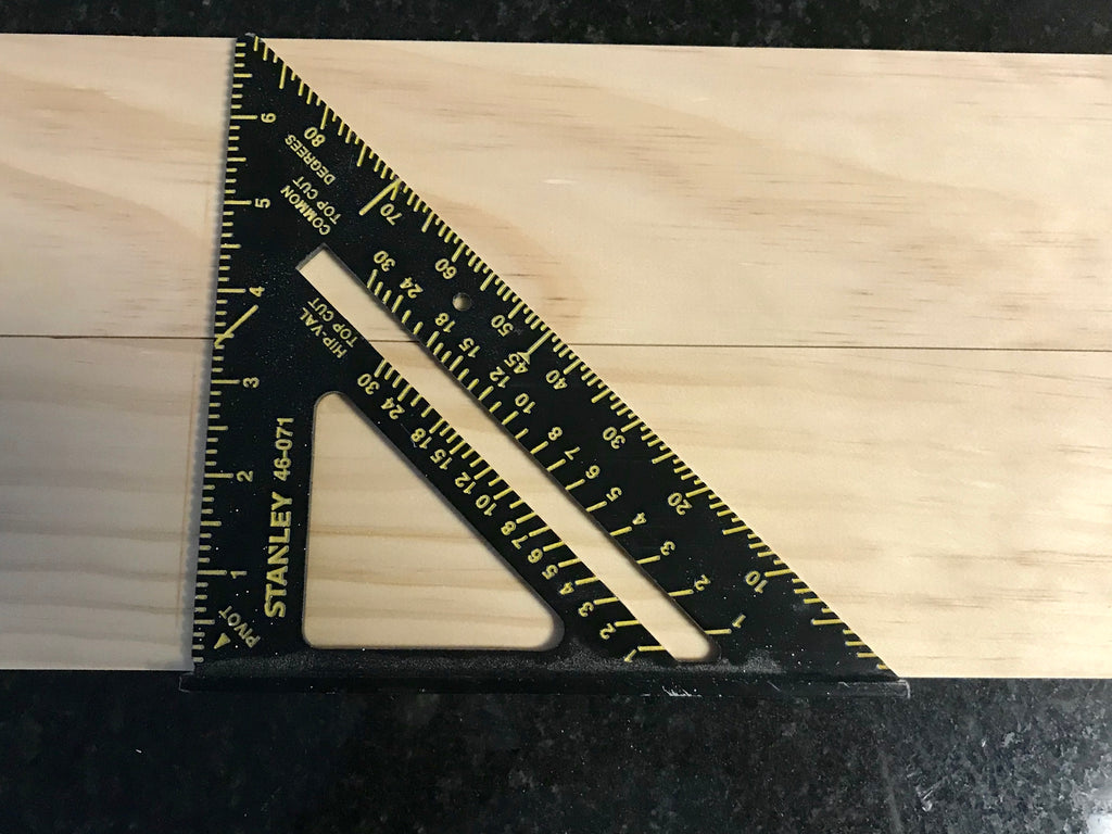 Using a speed square to measure lines for a magazine shelf rack