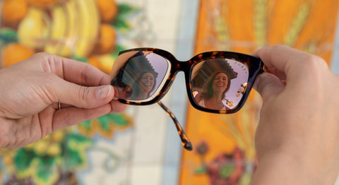 Rose Gold lenses in a Tortoise Frames with a mural in the background and the reflection of a women in the lenses