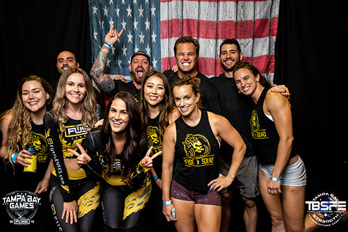 Smiling Fuse Crew in front of an American flag photo booth
