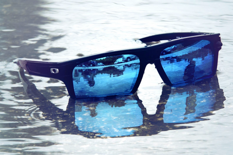 Pair of sunglasses with Glacier mirror lenses from Fuse Lenses sitting in a puddle