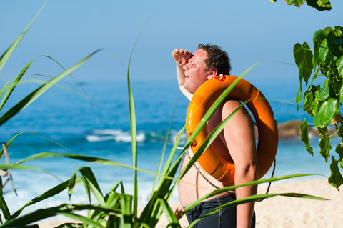 Man at beach squinting into the sun